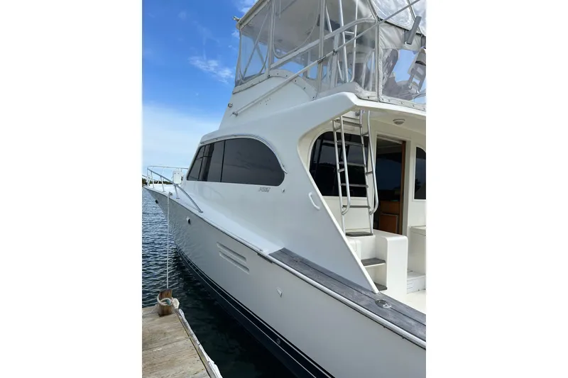 Slide: The Image of 1990 Post 46 Convertible yacht docked, showcasing sleek design and spacious deck. - 22