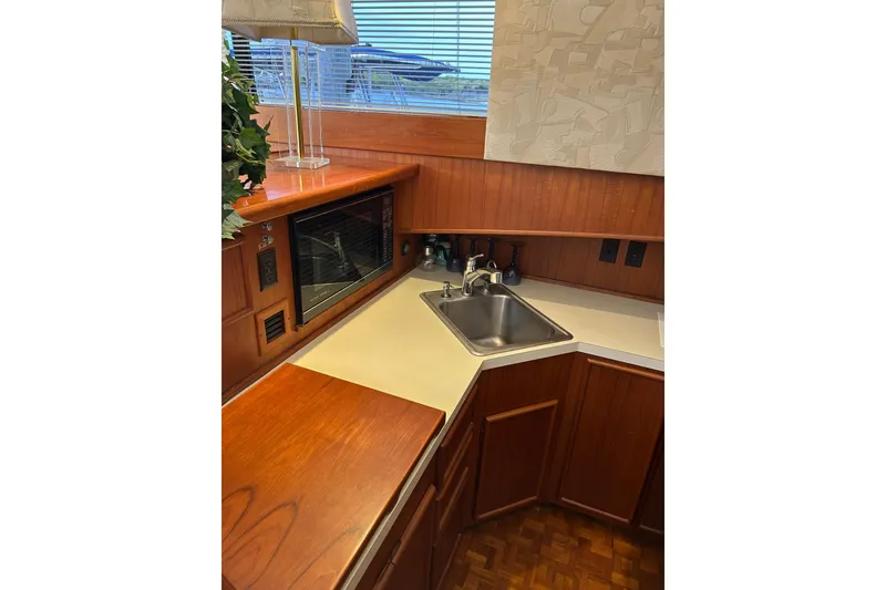 Slide: The Image of 1990 Post 46 Convertible yacht kitchen with wood cabinetry, sink, and microwave. - 7