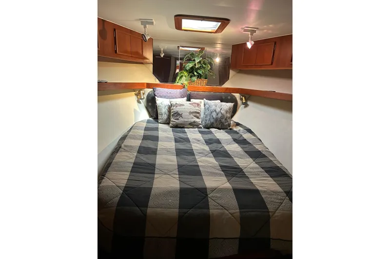 Slide: The Image of Cozy cabin bedroom in 1990 Post 46 Convertible yacht with checkered bedding and wooden cabinets. - 8