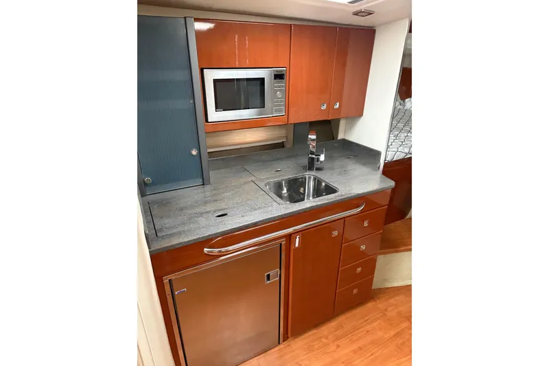 Slide: The Image of 2013 Formula 34 Performance Cruiser kitchen with microwave, sink, and wooden cabinetry. - 3