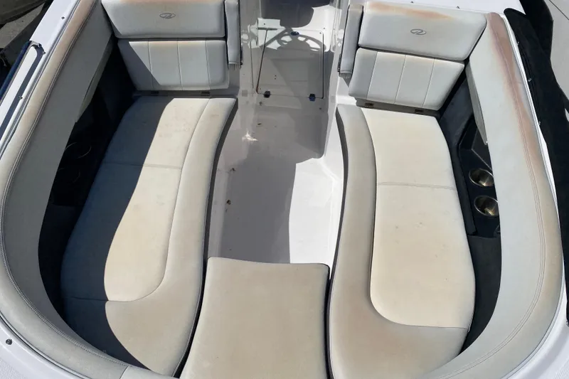 Slide: The Image of Interior seating of a 2013 Regal 27 FasDeck RX boat, featuring white cushioned seats. - 11