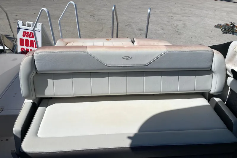 Slide: The Image of 2013 Regal 27 FasDeck RX boat seating, white upholstery, used boat sale sign in background. - 16
