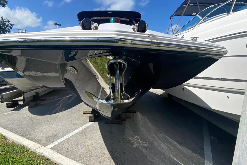 Slide: The Image of 2013 Regal 27 FasDeck RX boat with sleek hull design, parked on a sunny day. - 22