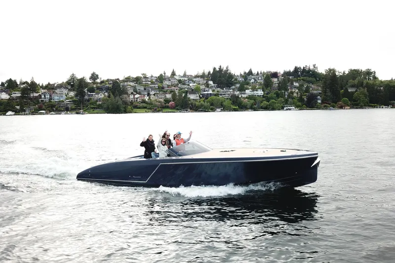 The Image of 2020 Frauscher 1017 GT cruising on a scenic lake with passengers waving. - 1