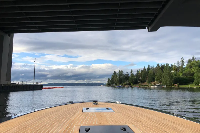 Slide: The Image of Frauscher 1017 GT boat under bridge, scenic lake view, cloudy sky, 2020 model. - 6