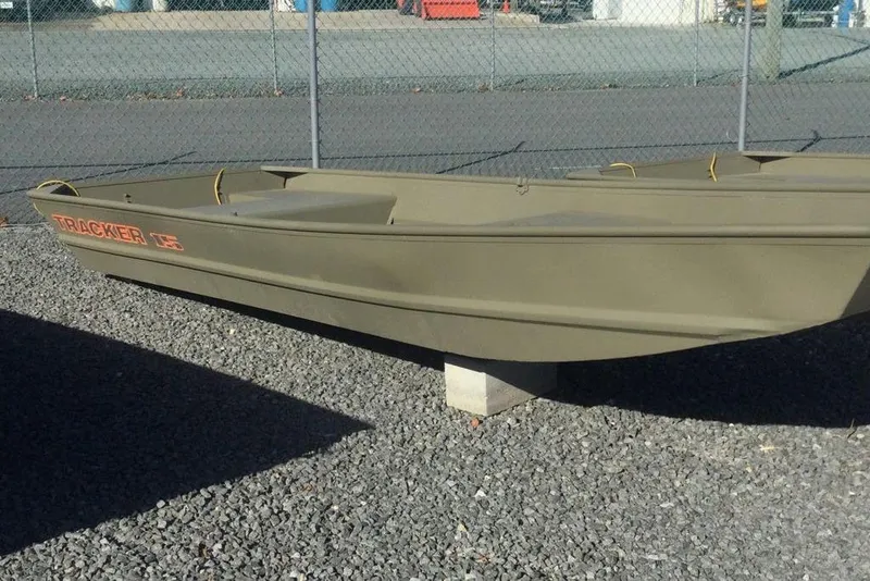 The Image of 2026 Tracker Grizzly 15 Jon boat on gravel, parked near a chain-link fence. - 0