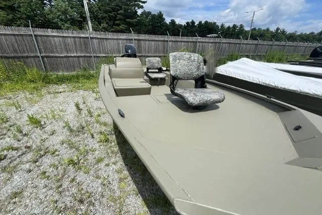 Slide: The Image of 2026 Tracker Grizzly 1754 SC boat with camo seats, parked outdoors on gravel. - 5