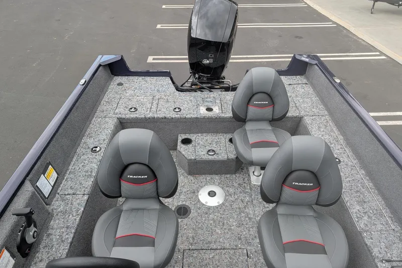 Slide: The Image of 2026 Tracker Pro Guide V-175 WT boat interior with four gray seats and motor. - 7