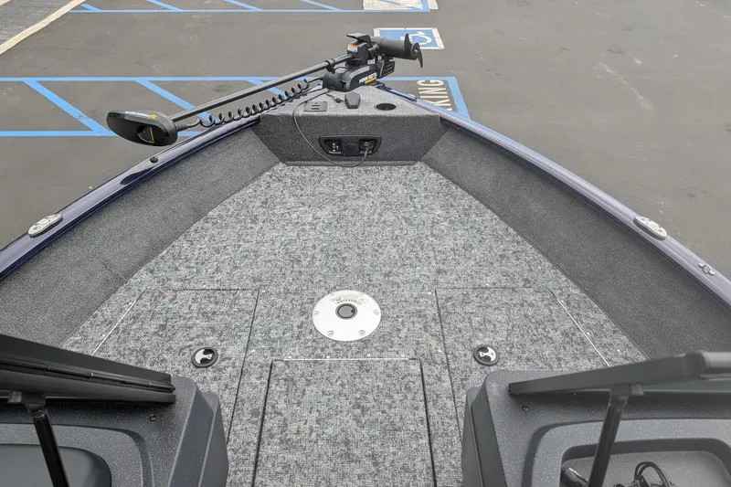 Slide: The Image of 2026 Tracker Pro Guide V-175 WT boat deck with trolling motor in parking lot. - 6