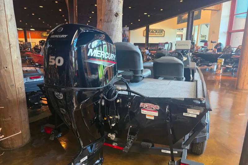 Slide: The Image of 2026 Tracker Bass Tracker Classic XL with Mercury 50 engine displayed indoors. - 4