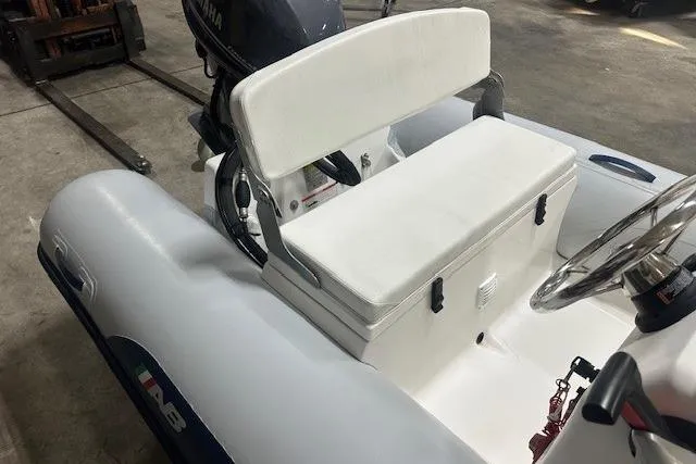 Slide: The Image of 2022 AB Inflatables Mares 11 VSX boat interior with white seating and steering wheel. - 5