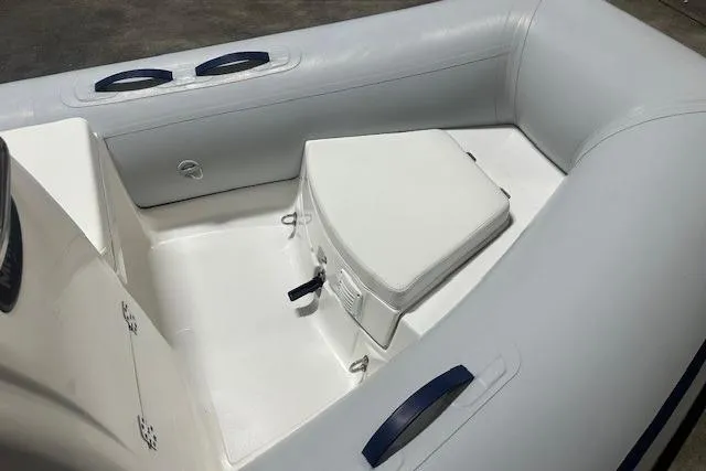Slide: The Image of 2022 AB Inflatables Mares 11 VSX boat interior with white seating and storage. - 7
