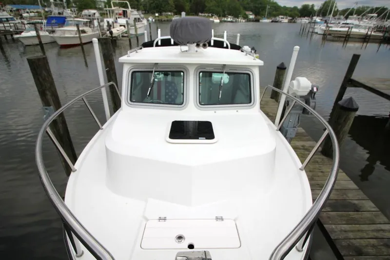 Slide: The Image of 2023 Parker 2320 Sport Cabin boat docked at a marina, front view. - 10