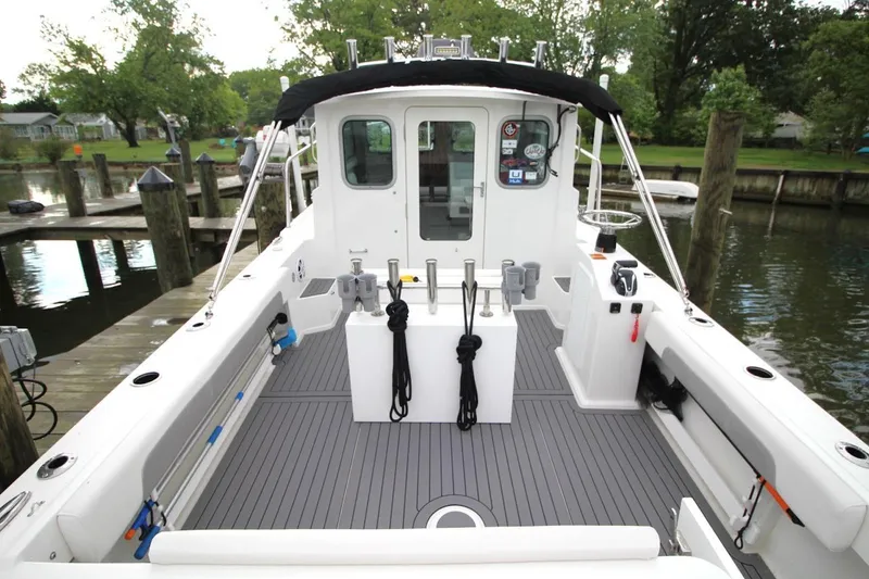 Slide: The Image of 2023 Parker 2320 Sport Cabin boat docked, featuring spacious deck and modern design. - 12