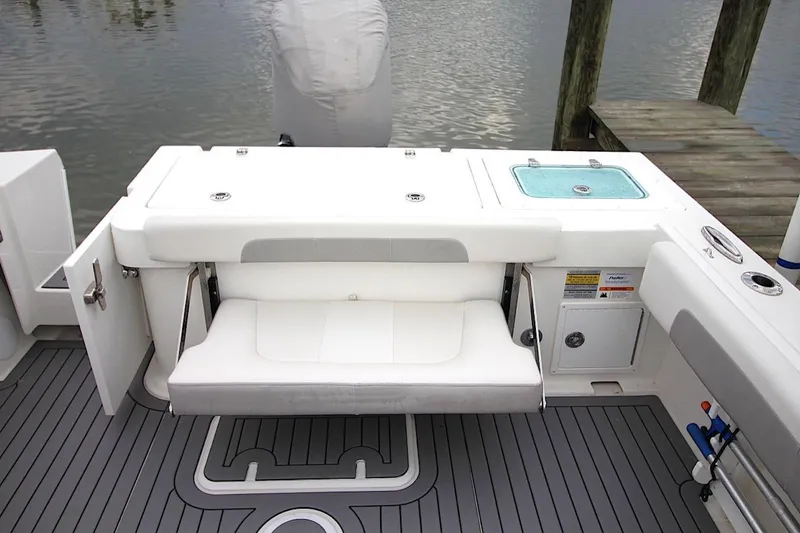 Slide: The Image of 2023 Parker 2320 Sport Cabin boat interior with foldable seat and storage compartments. - 14
