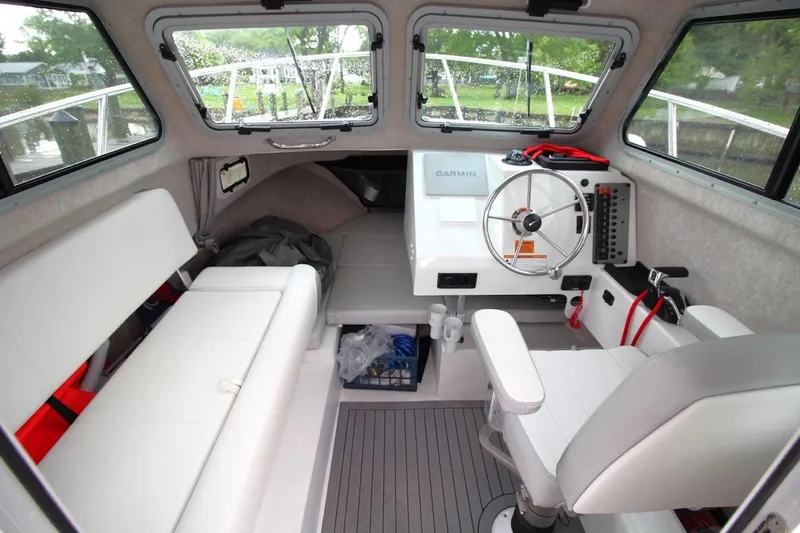 Slide: The Image of 2023 Parker 2320 Sport Cabin interior with steering wheel and seating. - 17