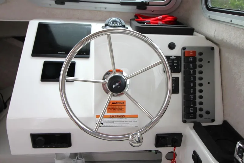 Slide: The Image of Steering wheel and dashboard of 2023 Parker 2320 Sport Cabin boat. - 19