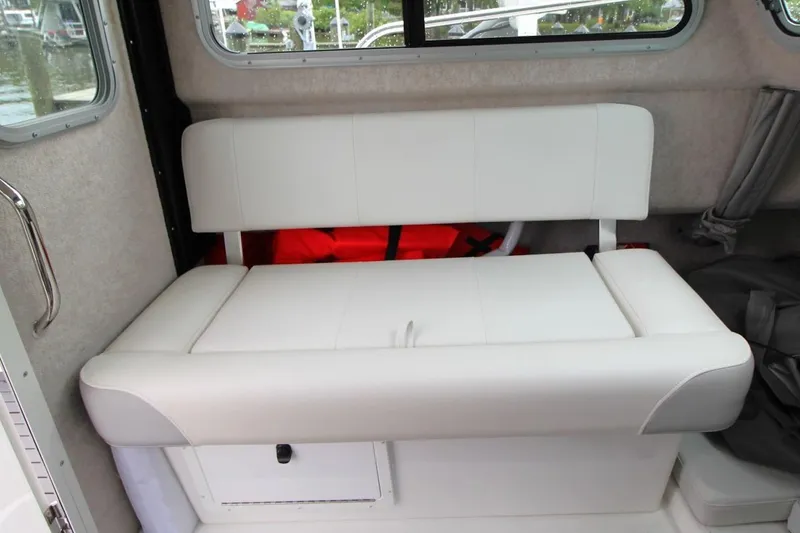Slide: The Image of 2023 Parker 2320 Sport Cabin interior with white cushioned seating and storage compartment. - 20