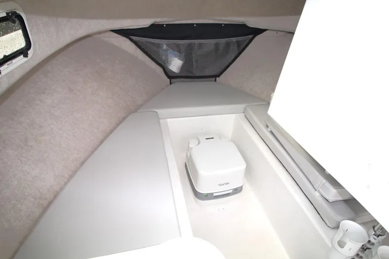 Slide: The Image of 2023 Parker 2320 Sport Cabin interior with compact toilet and cushioned seating. - 22