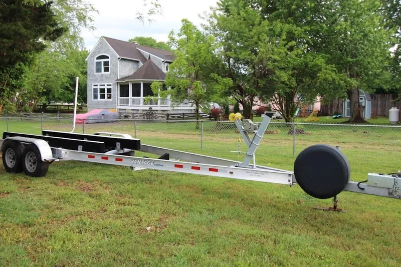 Slide: The Image of Trailer for 2023 Parker 2320 Sport Cabin boat on grassy yard near house. - 23