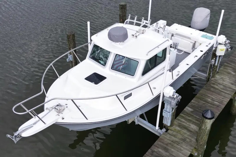 Slide: The Image of 2023 Parker 2320 Sport Cabin boat docked on calm water, showcasing sleek design and cabin features. - 5