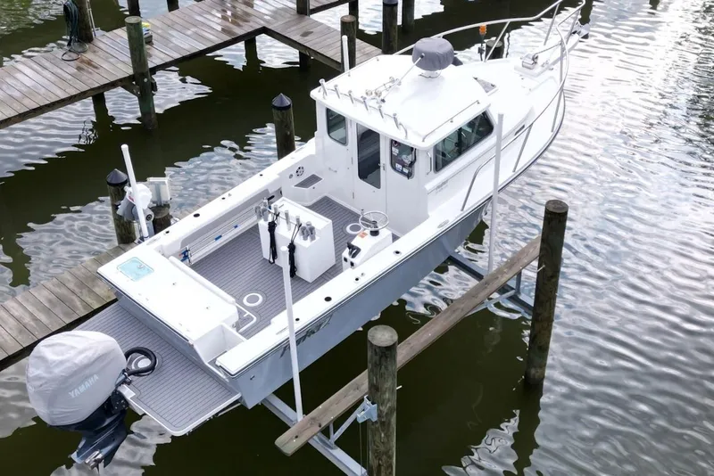Slide: The Image of 2023 Parker 2320 Sport Cabin boat docked on calm water, aerial view. - 7