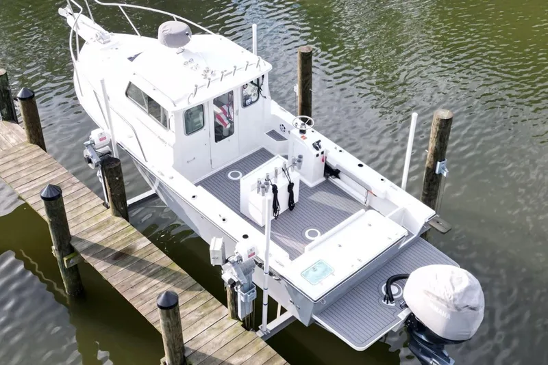 Slide: The Image of 2023 Parker 2320 Sport Cabin boat docked on calm water, aerial view. - 8