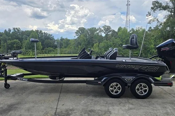 The Image of 2026 Nitro Z21 XL boat on trailer, parked outdoors with trees in background. - 0