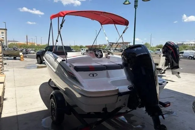 Slide: The Image of 2026 Tahoe T16 boat with red canopy and outboard motor on trailer. - 2