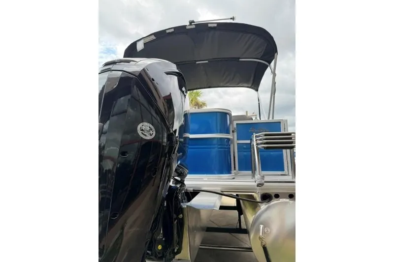 Slide: The Image of 2026 Sun Tracker Party Barge 18 DLX with outboard motor and canopy, rear view. - 4