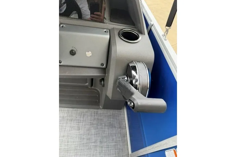 Slide: The Image of 2026 Sun Tracker Party Barge 18 DLX control panel with throttle lever and cup holder. - 8