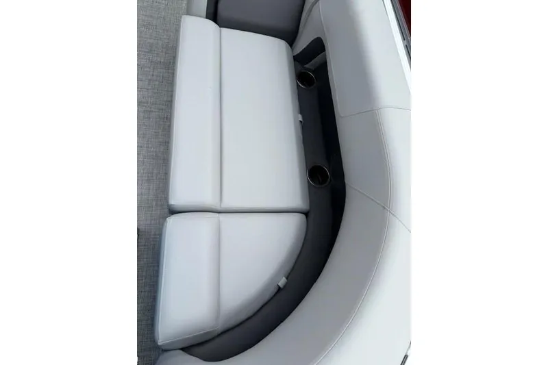 Slide: The Image of 2026 Sun Tracker Party Barge 18 DLX boat seating with cup holders, featuring white upholstery. - 18