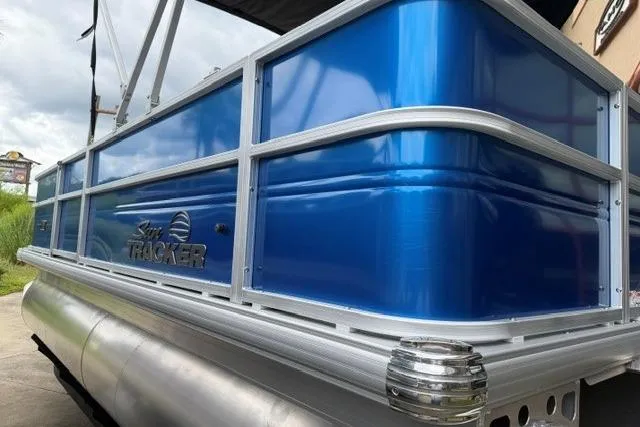 Slide: The Image of 2026 Sun Tracker Party Barge 18 DLX pontoon boat with blue exterior and sleek design. - 1