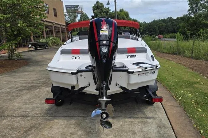 Slide: The Image of 2026 Tahoe T21 boat with outboard motor, parked on a concrete path near greenery. - 6