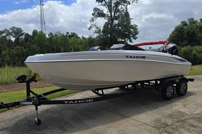 Slide: The Image of 2026 Tahoe T21 boat on trailer, parked outdoors with trees in the background. - 3