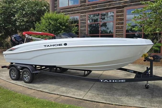 Slide: The Image of 2026 Tahoe T21 boat on trailer, parked outdoors near a building. - 1