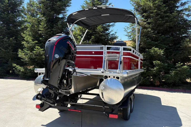 Slide: The Image of 2026 Sun Tracker SportFish 20 DLX pontoon boat with outboard motor, parked outdoors. - 3