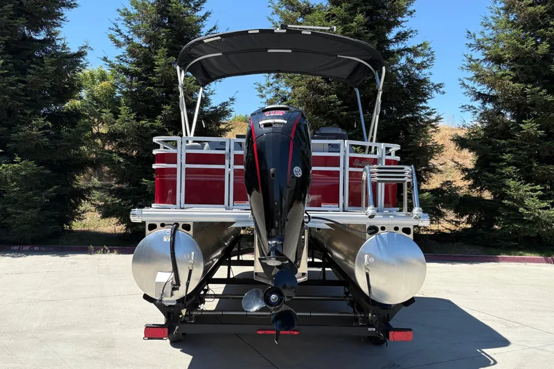 Slide: The Image of 2026 Sun Tracker SportFish 20 DLX pontoon boat with outboard motor, parked outdoors. - 9