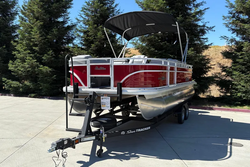 Slide: The Image of 2026 Sun Tracker SportFish 20 DLX pontoon boat on trailer, parked outdoors. - 7
