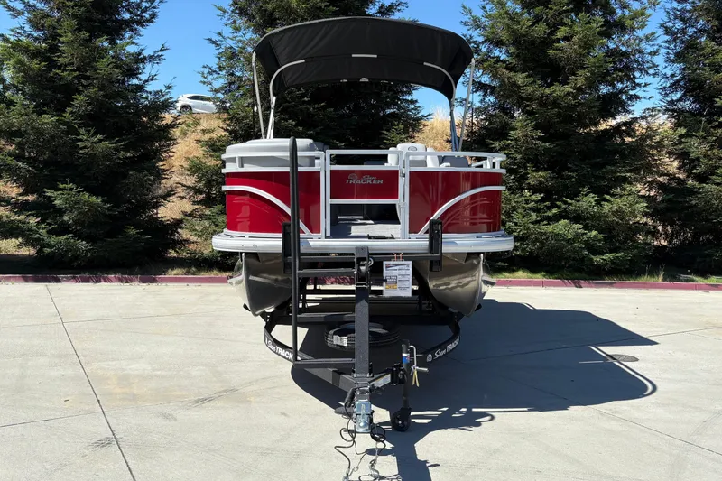 Slide: The Image of 2026 Sun Tracker SportFish 20 DLX pontoon boat on trailer, parked outdoors. - 6