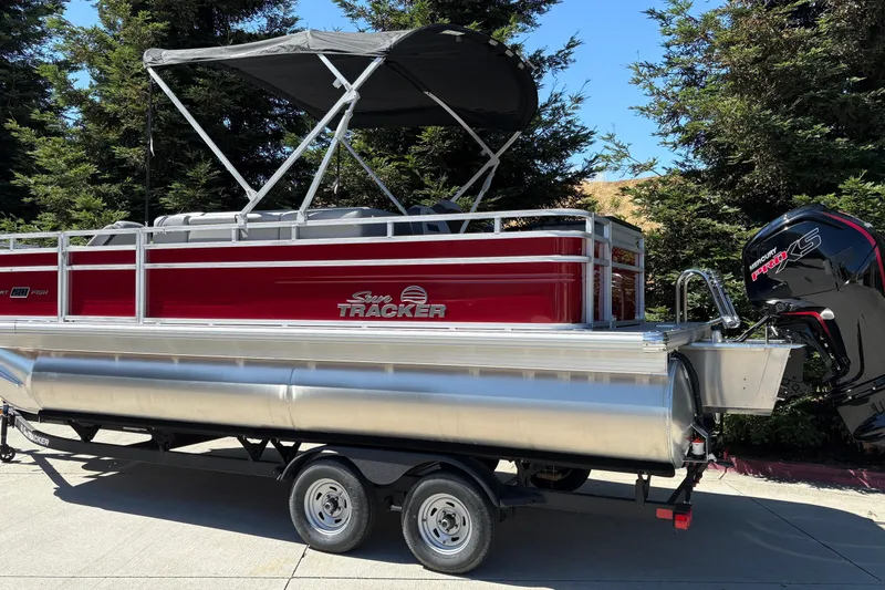 Slide: The Image of 2026 Sun Tracker SportFish 20 DLX pontoon boat with canopy and outboard motor. - 2
