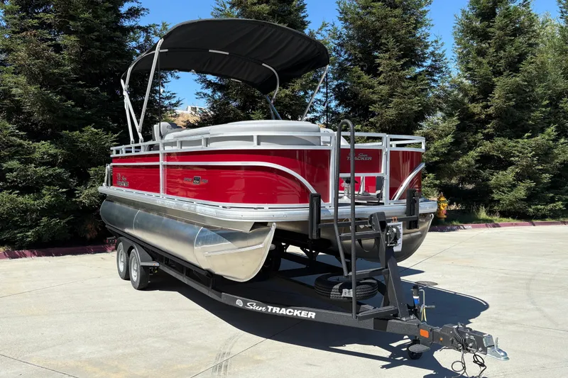 Slide: The Image of 2026 Sun Tracker SportFish 20 DLX pontoon boat on trailer, parked outdoors. - 5