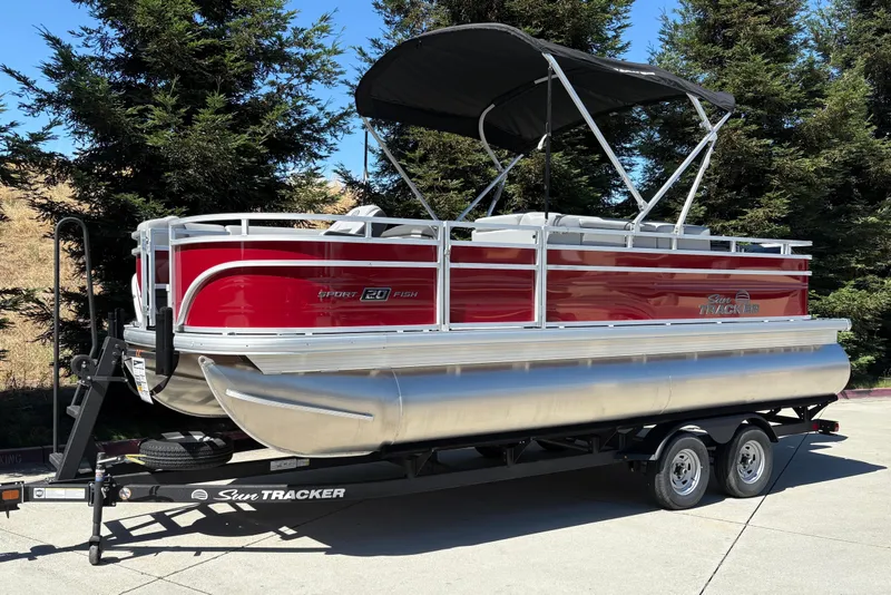 Slide: The Image of 2026 Sun Tracker SportFish 20 DLX pontoon boat on trailer, parked outdoors. - 8