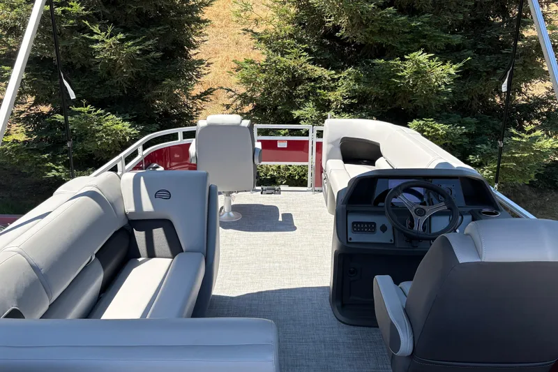 Slide: The Image of 2026 Sun Tracker SportFish 20 DLX pontoon boat interior with plush seating and steering console. - 13