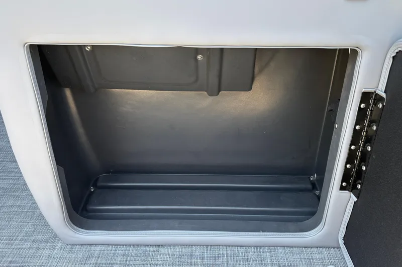 Slide: The Image of Storage compartment of 2026 Sun Tracker SportFish 20 DLX boat, featuring a hinged door. - 23