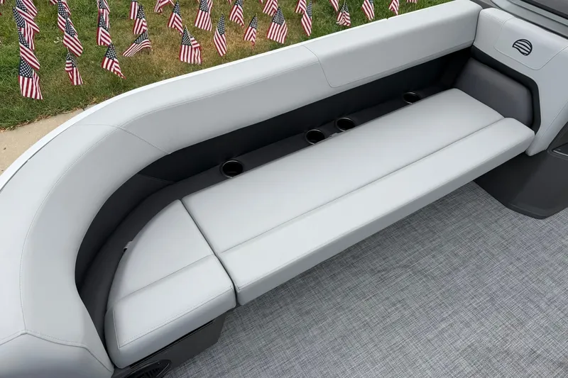 Slide: The Image of Interior seating of 2026 Sun Tracker Party Barge 18 DLX with cup holders and American flags. - 13