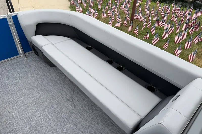 Slide: The Image of 2026 Sun Tracker Party Barge 18 DLX interior with gray seating and cup holders. - 14