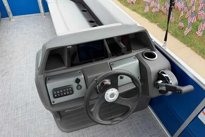 Slide: The Image of 2026 Sun Tracker Party Barge 18 DLX helm with steering wheel and control panel. - 17