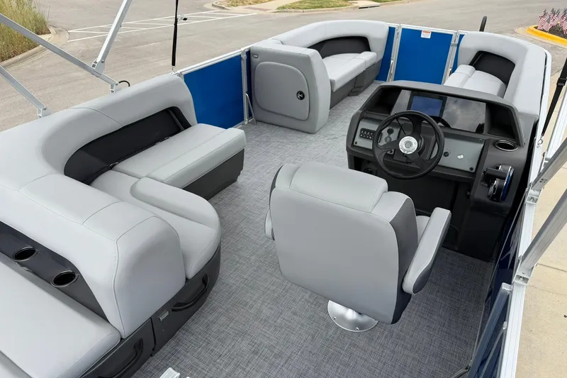 Slide: The Image of 2026 Sun Tracker Party Barge 18 DLX interior with gray seating and modern helm. - 18