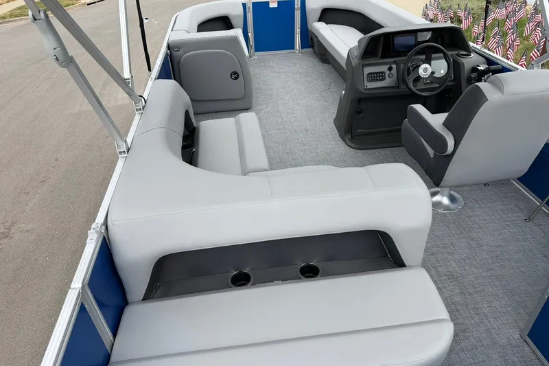Slide: The Image of 2026 Sun Tracker Party Barge 18 DLX interior with gray seating and steering console. - 20